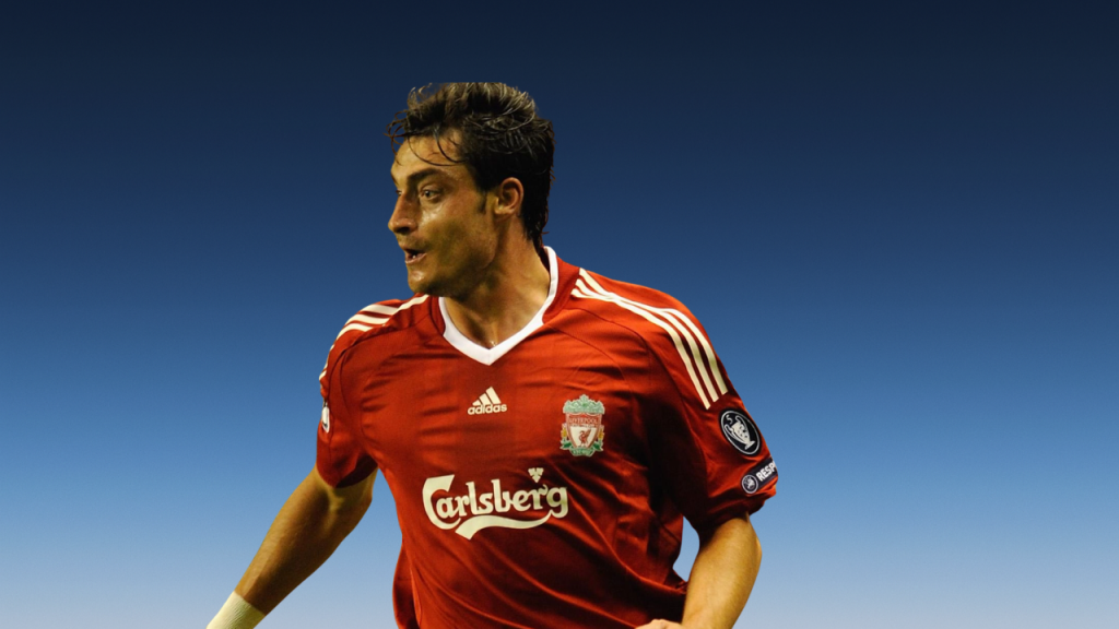 Albert Riera smiling during a football match as the former Spanish winger and Liverpool player leads his team on the field.