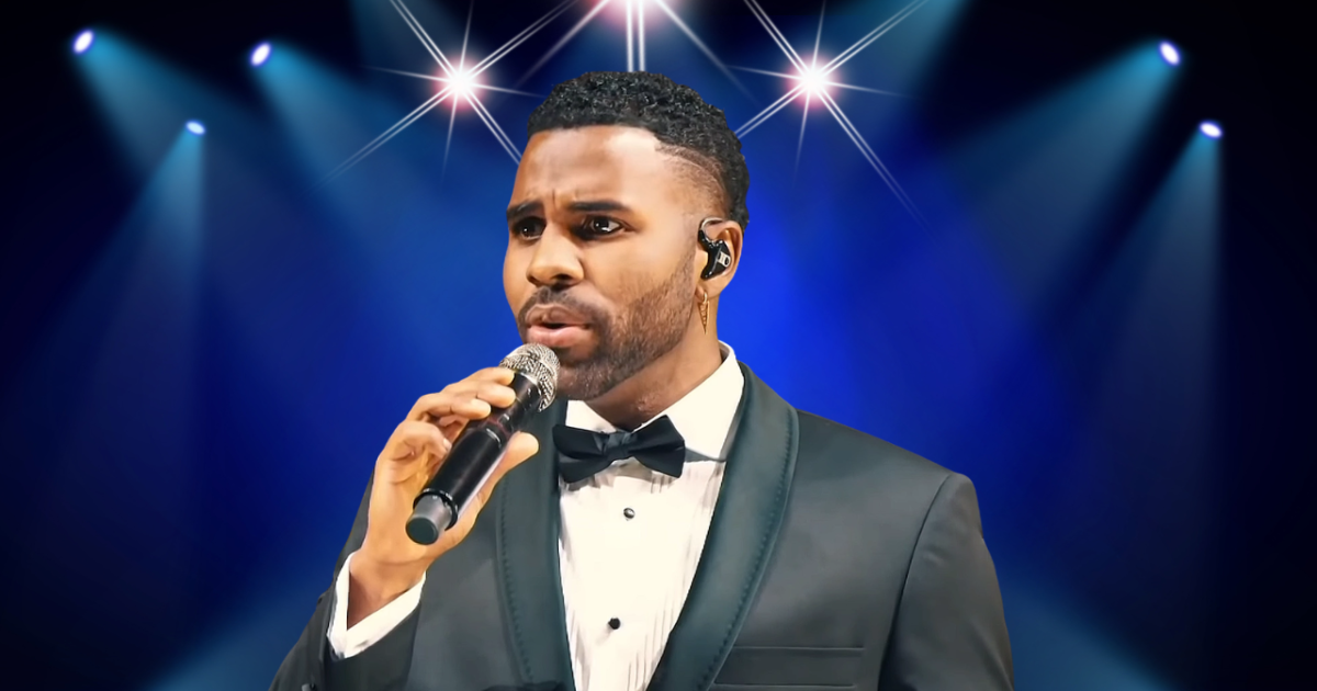 Jason Derulo performing live on stage with energetic dance moves and bright concert lights behind him
