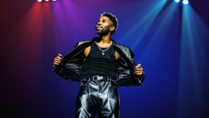 Jason Derulo singing passionately into a microphone during a high-energy pop concert performance